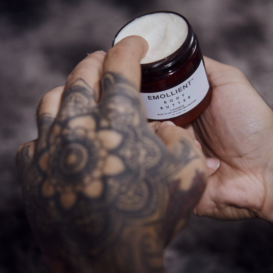 A man’s hands scooping My Emollient body butter from the jar, highlighting a masculine, skincare moment. This customer says it keeps his skin moisturized all day and smells great.